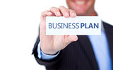 Businessman holding a label with business plan written on it