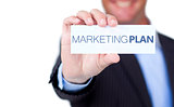 Businessman holding a label with marketing plan written on it