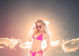 Blonde woman with sunglasses posing under the sun
