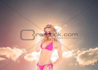 Blonde woman with sunglasses posing under the sun