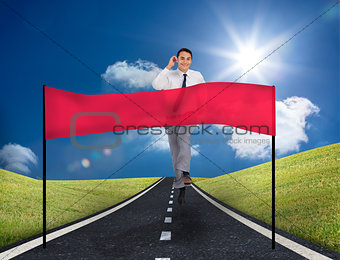 Smiling young businessman running on a road with copy space banner