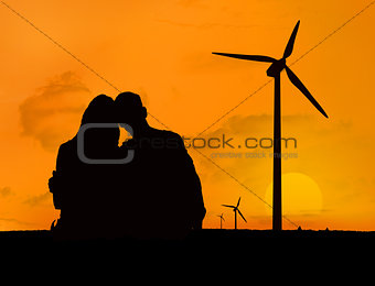 Couple embracing in front of a sunset