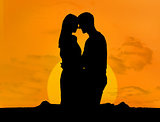 Silhouette of couple embracing under a sunset