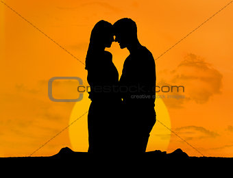 Silhouette of couple embracing under a sunset