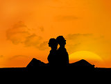 Silhouette of couple relaxing under a sunset