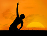 Silhouette of woman doing yoga under sunset