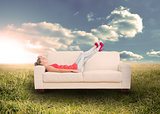 Woman relaxing on couch in field