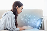 Woman using laptop with binary codes floating over