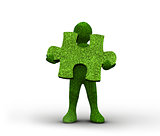 Green human representation holding a grass jigsaw puzzle