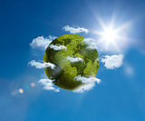 Green planet floating bright blue sky