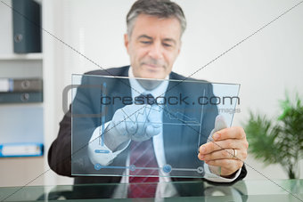 Businessman using futuristic touchscreen to view graph