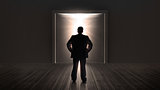 Businessman watching doors opening to a bright light