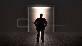 Businessman watching doors opening to a bright light
