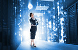 Businesswoman standing and looking thoughtful in data center