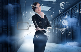 Businesswoman standing in data center with currency graphics