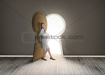 Businesswoman leaning against keyhole shaped doorway