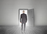 Businessman walking towards door showing light