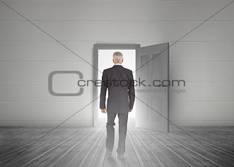 Businessman walking towards door showing light
