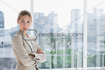 Blonde businesswoman standing with arms crossed