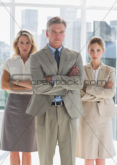 Three serious business people standing together
