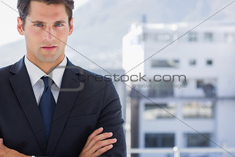 Handsome businessman standing with arms folded