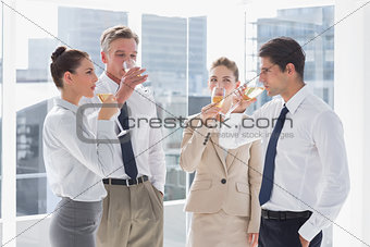Smiling team of business people drinking champagne