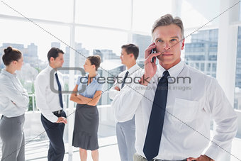 Boss on the phone standing in a modern office
