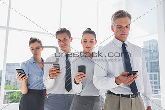 Team of business people standing together in line with their mobile