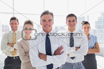 Smiling business people with arms crossed in their office