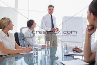 Smiling businessman standing in front of a whiteboard