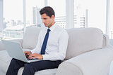 Businessman using laptop on a couch