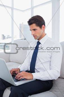 Attractive businessman typing on his laptop