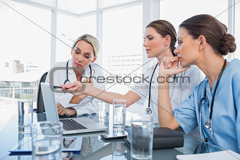 Doctor showing something on a laptop to her colleagues