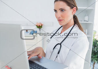 Serious woman doctor using a laptop
