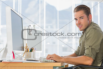 Smiling creative business employee working on computer