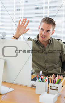 Creative business employee waving in a modern office