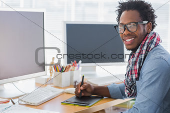 Smiling graphic designer using a graphics tablet
