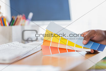 Hand holding colour charts in a modern office