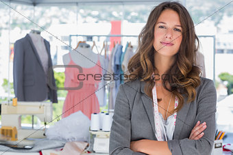 Smiling fashion designer with arms folded