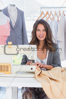 Fashion designer sewing textile