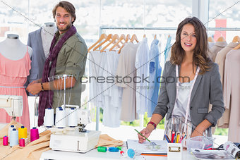 Fashion designers working and smiling at camera