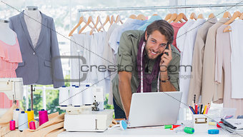 Smiling fashion designer using laptop
