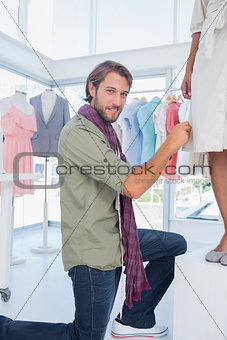 Fashion designer smiling to the camera and picking needles