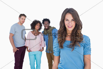 Stylish woman smiling with people gesturing behind her