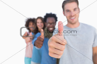 Young people in row with thumbs up