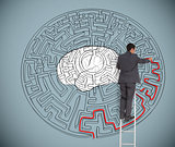 Businessman trying to solve a large maze with a brain illustration
