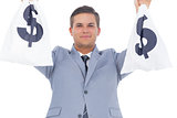 Businessman raising hands with money bags