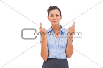 Smiling businesswoman with fingers crossed