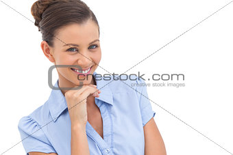 Cheerful businesswoman with hand on chin