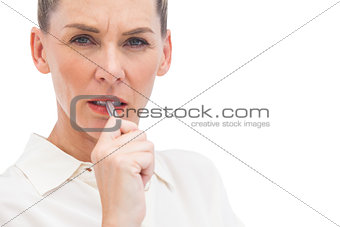 Worried businesswoman with pen on mouth